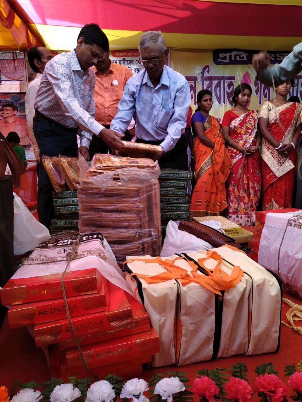 People handing out essential goods at a community ceremony